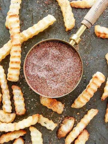top down view of fry seasoning with seasoned fries scattered around it.