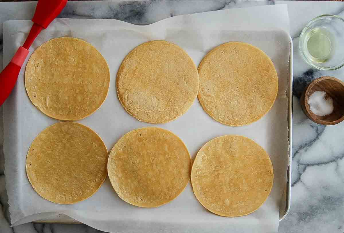 corn tortillas on sheet pan brushed with oil.