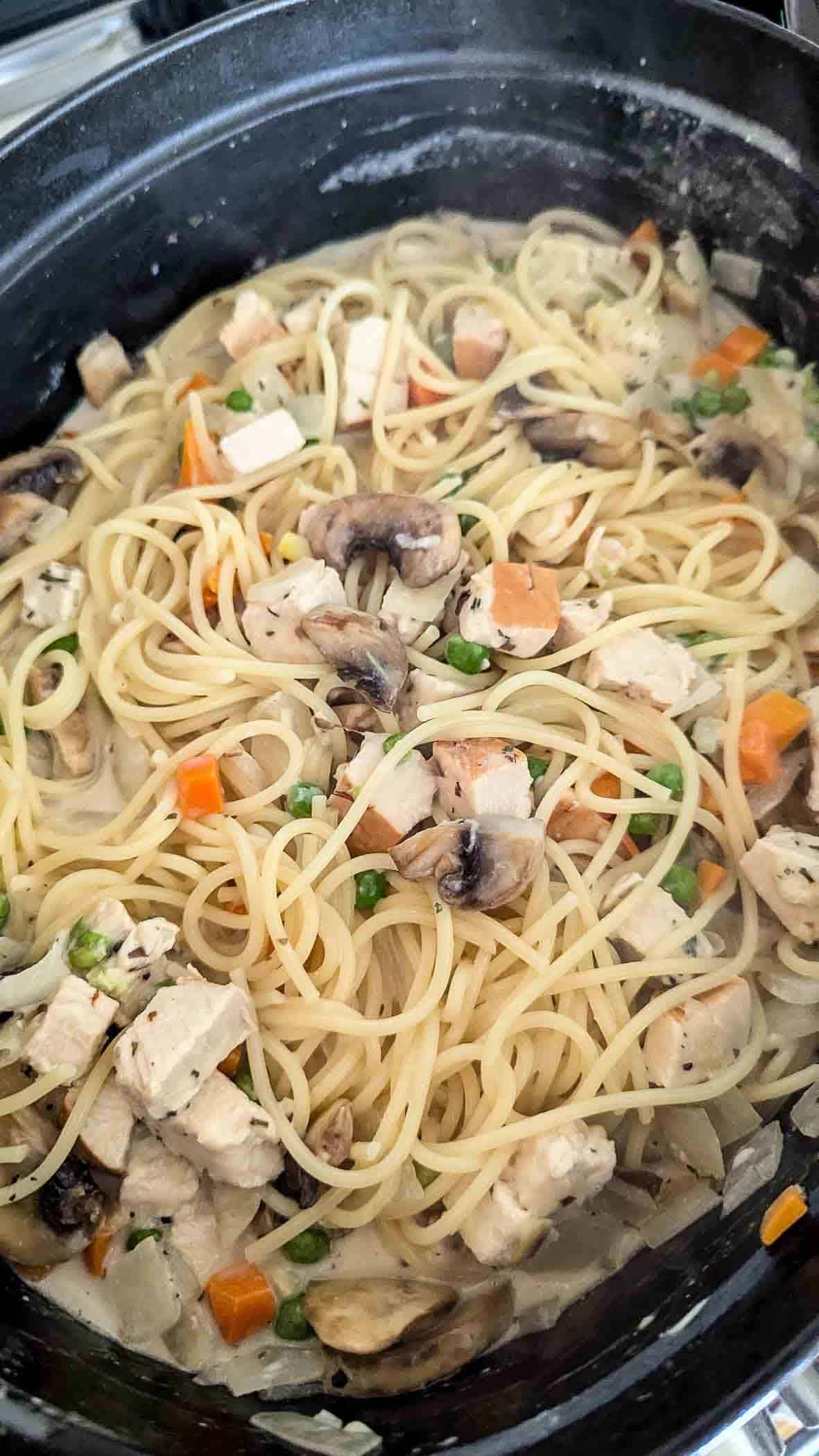 turkey tetrazzini cooking in dutch oven on stovetop.