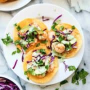 Shrimp tostadas on plate with cilantro lime cream sauce.