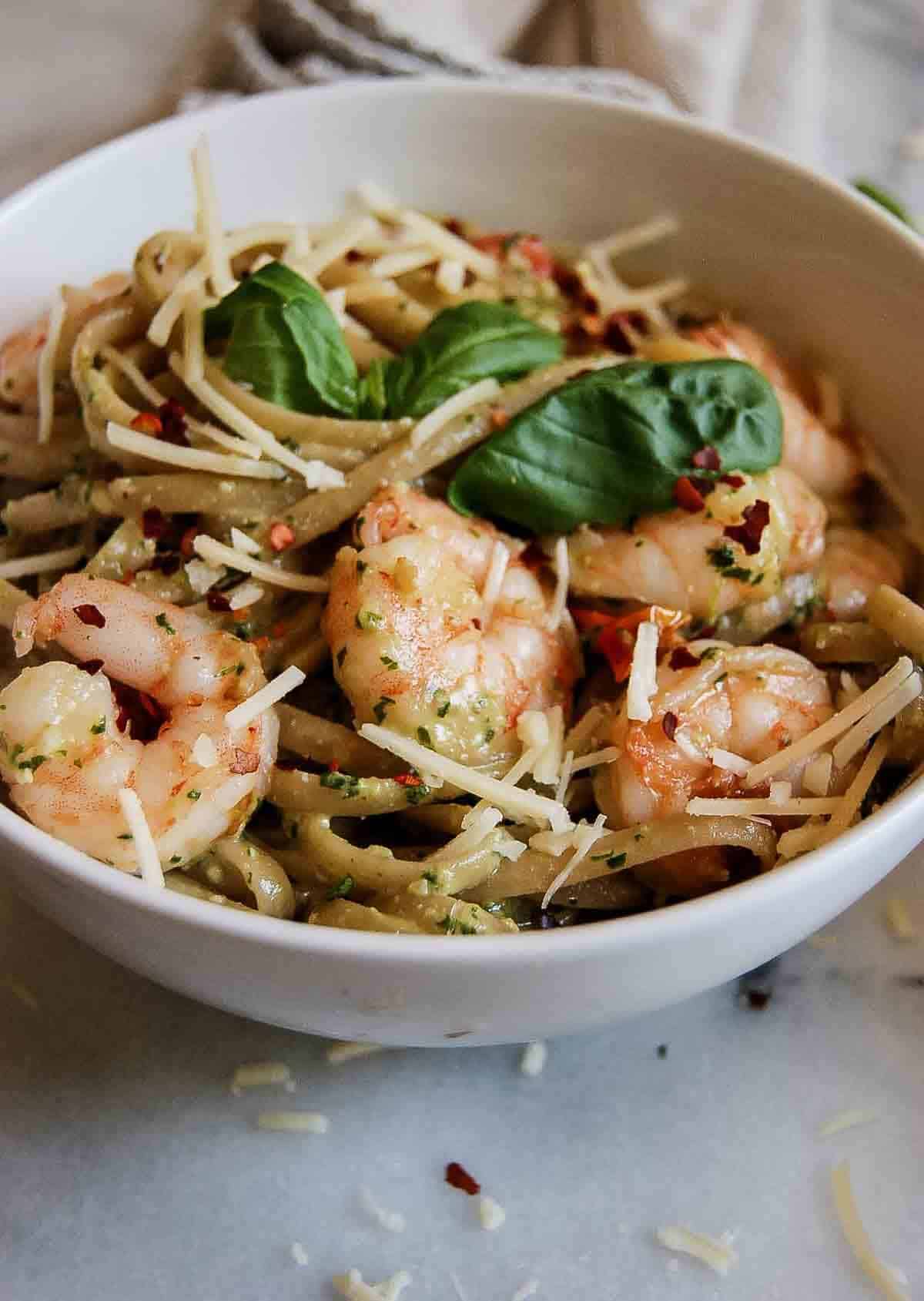 side view of shrimp pesto pasta in bowl.