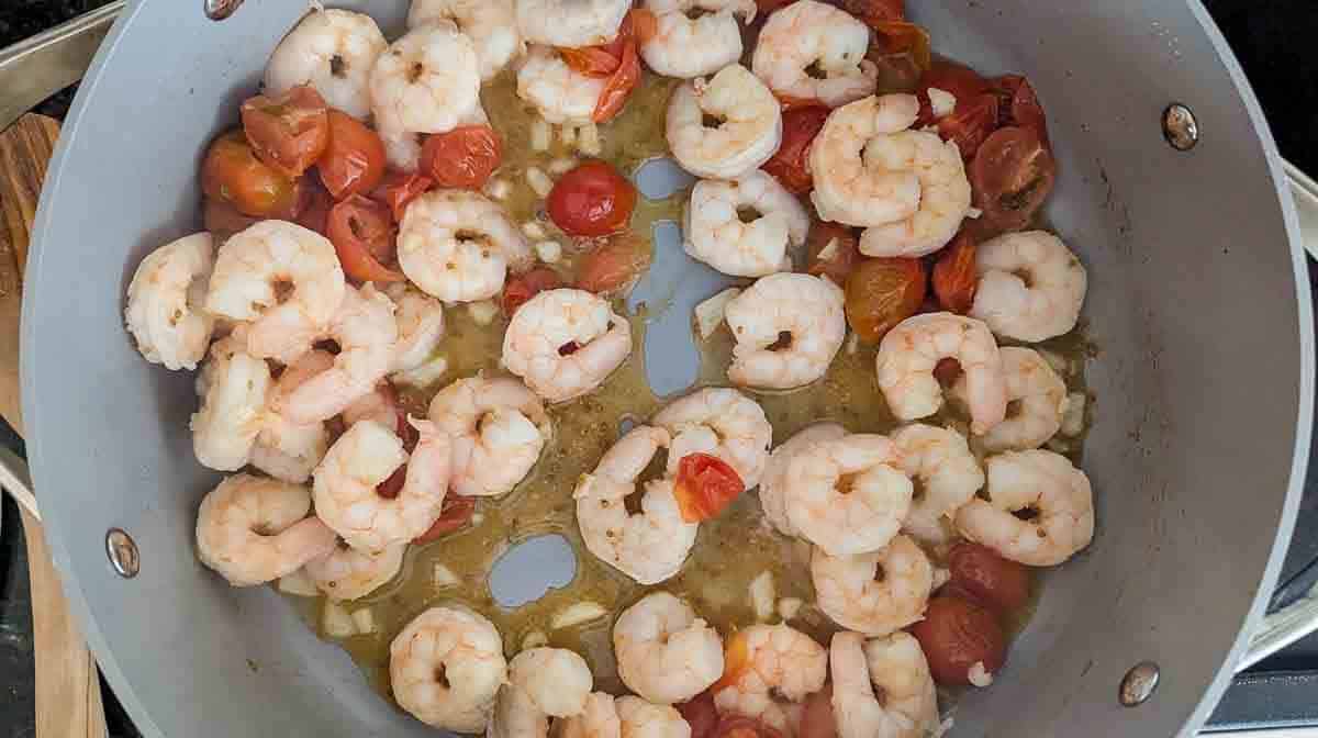 tomatoes, shrimp and garlic sauteeing in pan.