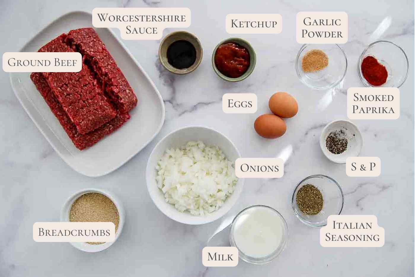 ingredients for mini meatloaf on a white marble countertop.