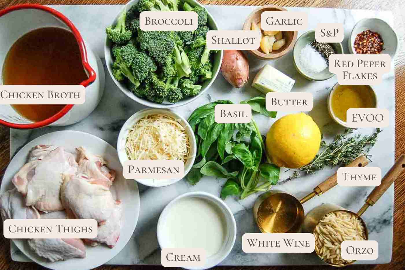 Ingredients for lemon chicken orzo laid out on a white surface.