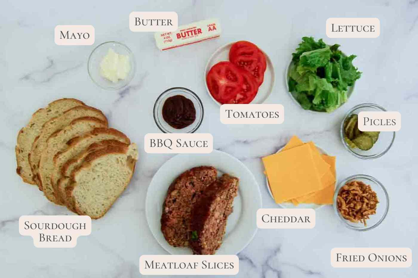 Ingredients for a meatloaf sandwich, labeled, on a countertop.