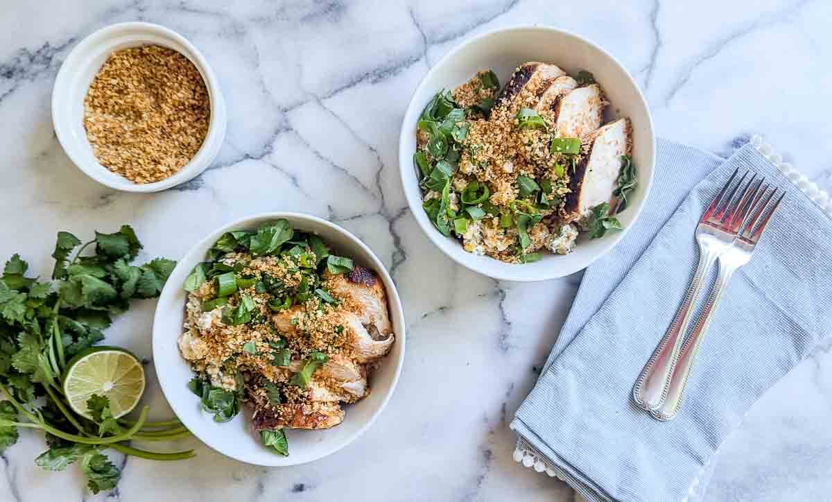 two street corn chicken rice bowls on a countertop.