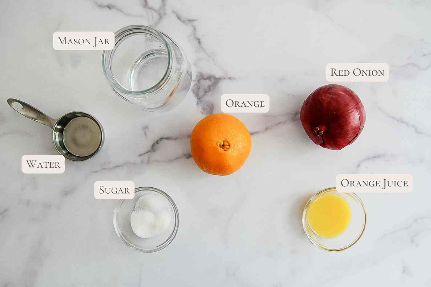 Ingredients for quick pickled red onions on a marble surface.
