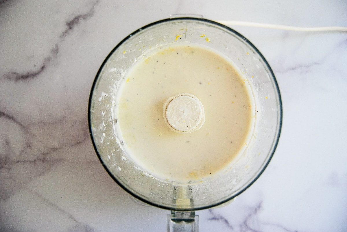 food processor bowl filled with a creamy whipped feta dip.