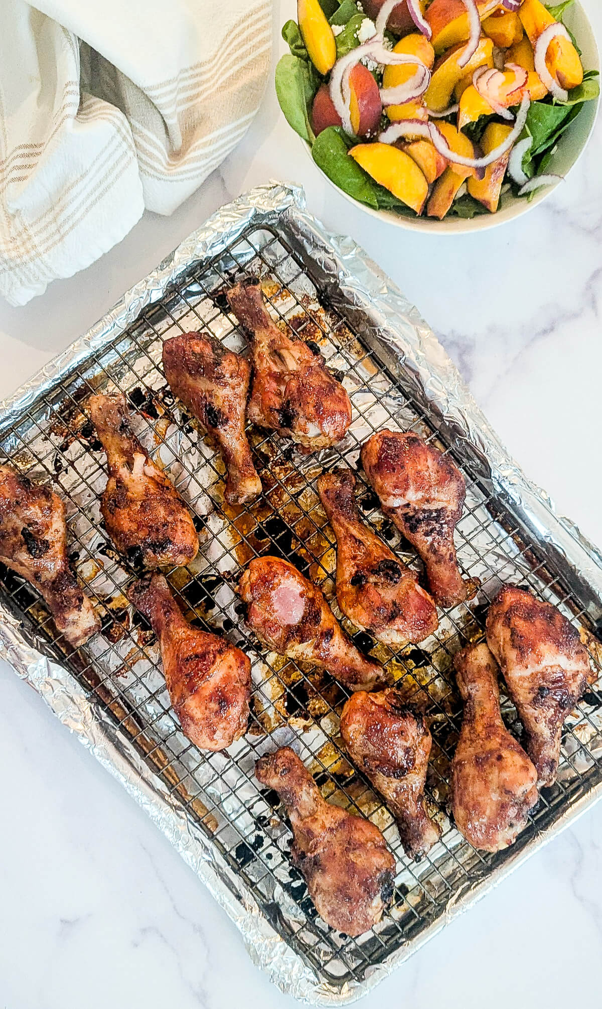 Baked bbq chicken drumsticks on a foil-lined rack.