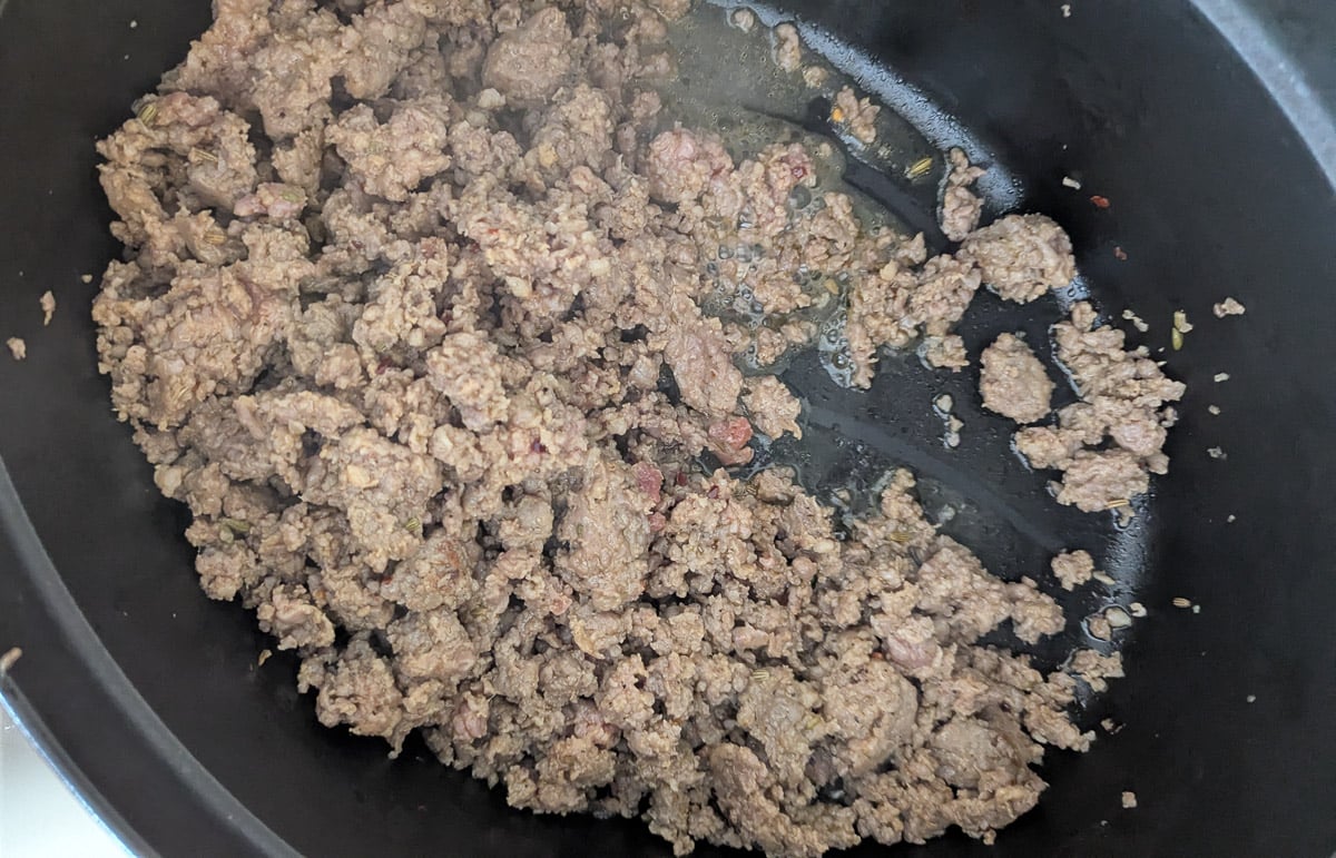 Ground meat browning in a pan.